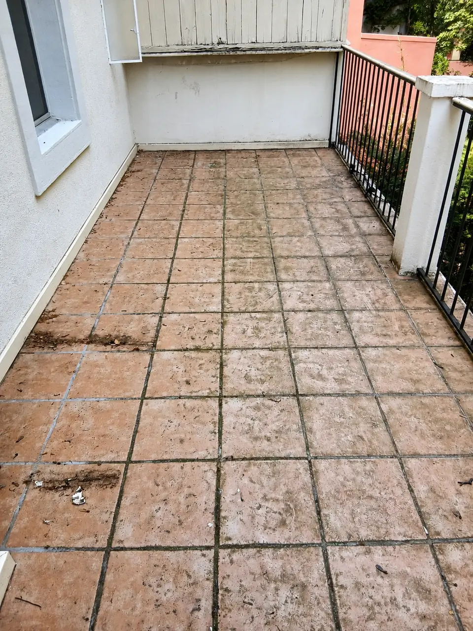 Balcon carrelé avant nettoyage de fin de bail, avec salissures et traces vertes sur les joints